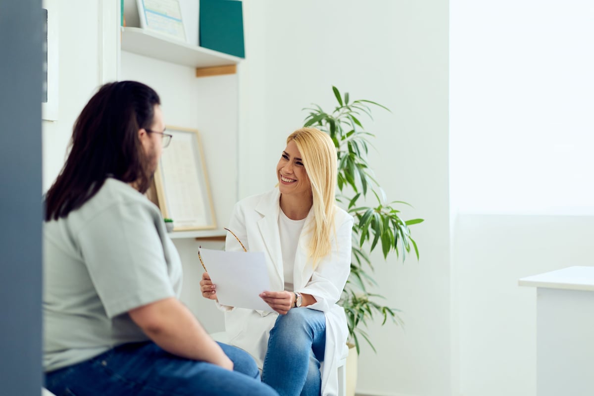 A health practitioner and client in a friendly consultation, reviewing notes together in a bright office